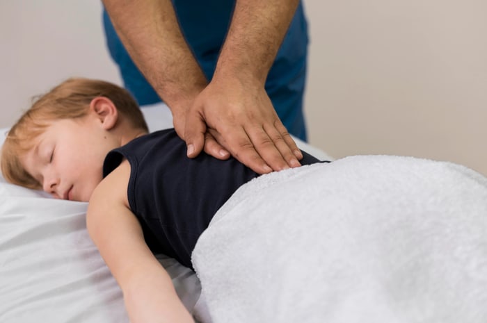 Young child resting comfortably while receiving a gentle, low-force back adjustment