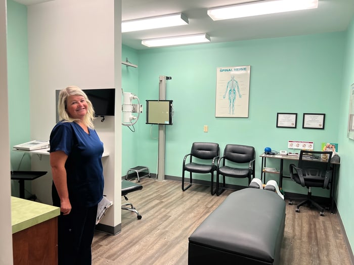 ProWellness team member standing in a treatment room beside the therapy table